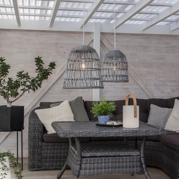 Terrasse mit Rattansitzgruppe, Tisch, Topfpflanzen und zwei hängenden Rattanlampen