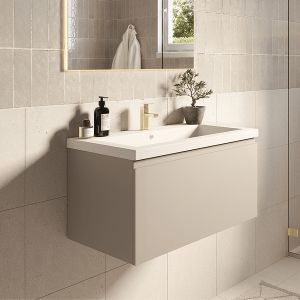 Modernes Badezimmer mit wandhängendem Waschbeckenunterschrank, Keramikwaschbecken und Armatur. Beleuchteter Spiegel an der gefliesten Wand.