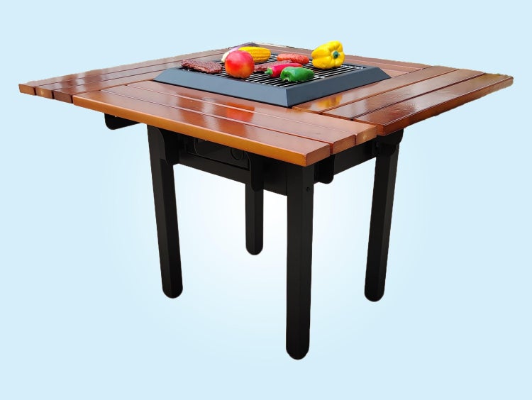 Holztisch mit integriertem Grill in der Mitte, schwarze Tischbeine und Grillgut auf dem Rost.