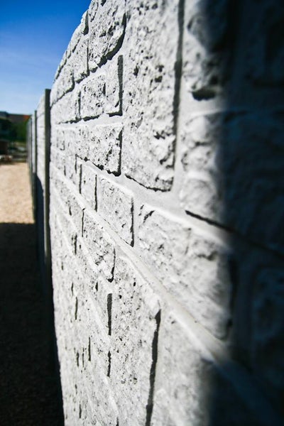 Nahaufnahme einer Gartenmauer aus Beton in Steinoptik.