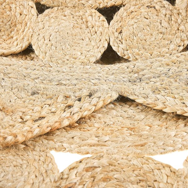 Nahaufnahme eines geflochtenen Teppichs aus Jute mit runden Mustern aus Naturfasern.