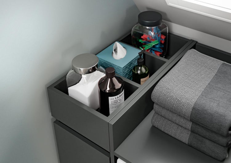 Badezimmer-Aufbewahrungssystem mit grauen Einsätzen, Glasbehältern, Flasche, Taschentuchbox und gestapelten grauen Handtüchern.