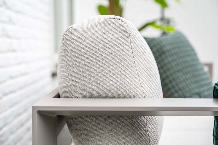 Detailaufnahme eines gewebten Polsters und Metallrahmens eines Garten-Loungesessels.