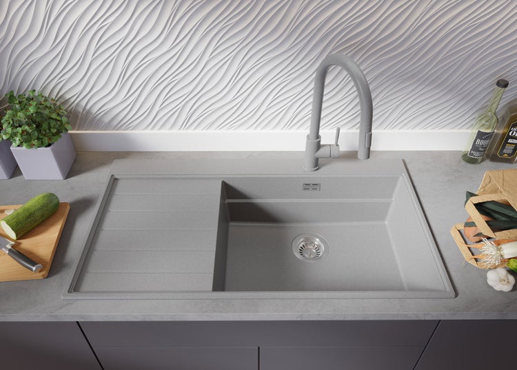 Küchenspüle mit Abtropffläche und Armatur auf einer Arbeitsplatte mit Lebensmitteln