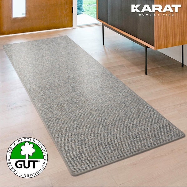 Moderner Teppichläufer mit Rippenstruktur auf hellem Holzboden im Wohnraum. Karat Home and Living Logo. Geprüft auf Umweltfreundlichkeit.