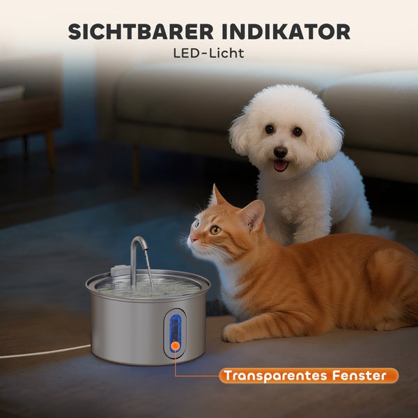 Edelstahl-Trinkbrunnen für Haustiere mit Wasserhahn, Lichtanzeige und Sichtfenster in einem hellen Wohnzimmer mit Hund und Katze.