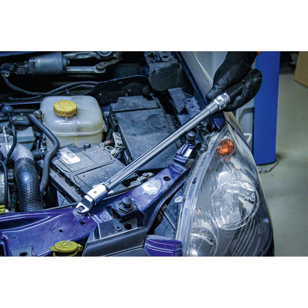 Drehmomentschlüssel im Einsatz am Motorraum eines Autos