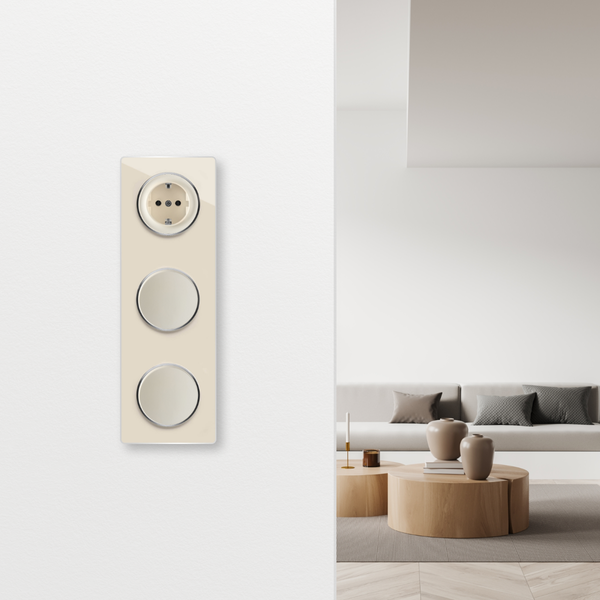 Eine dreifache Kombination aus Steckdose und Lichtschaltern an einer Wand in einem modernen Wohnzimmer mit Sofa und Holztischen.