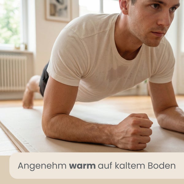 Mann macht eine Plank-Übung auf einer wärmeisolierenden Bodenmatte aus Schaumstoff in einem hellen, aufgeräumten Innenraum.