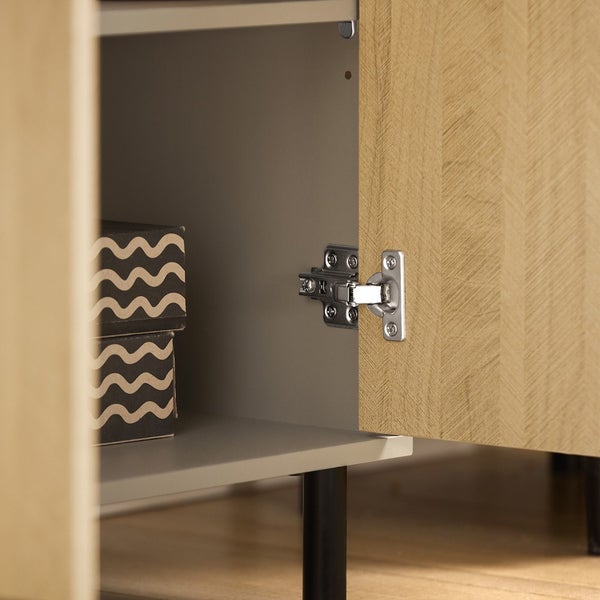 Detailaufnahme eines Möbelstücks mit offenem Schrankfach und zwei dekorativen Schachteln