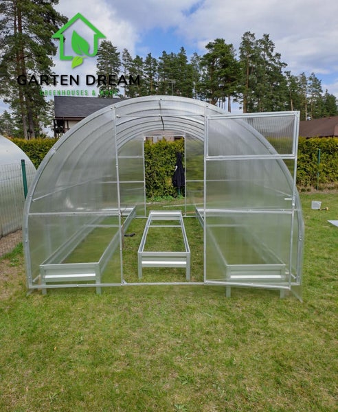 Gartengewächshaus mit transparenten Wänden und Rahmenstruktur auf Rasenfläche