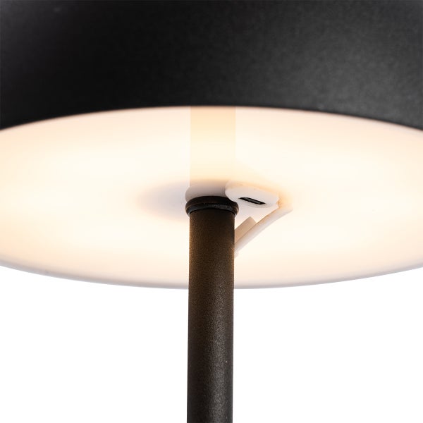 Nahaufnahme der Unterseite einer schwarzen Leuchte mit beleuchtetem Diffusor und USB-Ladeanschluss.