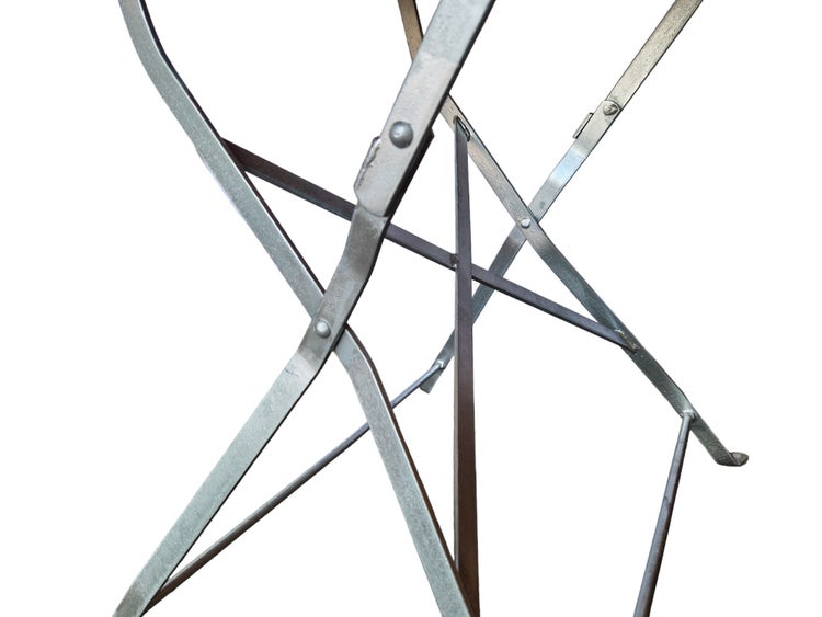 Nahaufnahme eines stabilen Metallgestells mit Klappmechanismus und vernieteten Verbindungsstellen.