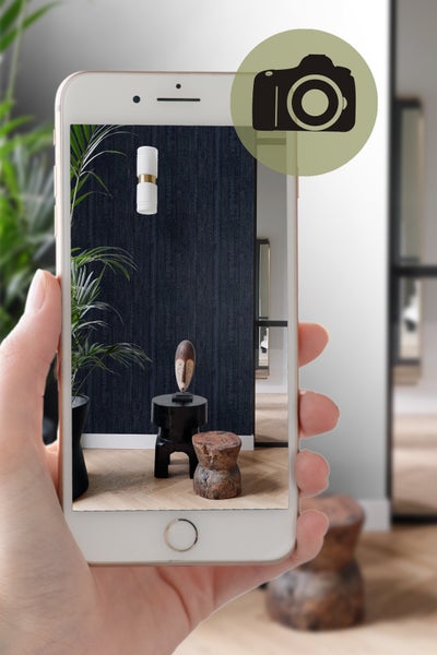 Ansicht eines Zimmers durch ein Smartphone mit Wandleuchte und Dekoration