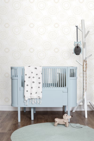 Kinderzimmer mit Gitterbett, Spielzeug und Baumgarderobe