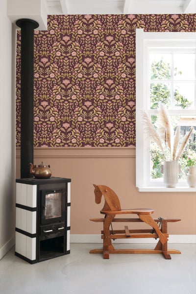 Ein Wohnzimmer mit einem Kaminofen, einer Holzkutsche und einer floralen Tapete