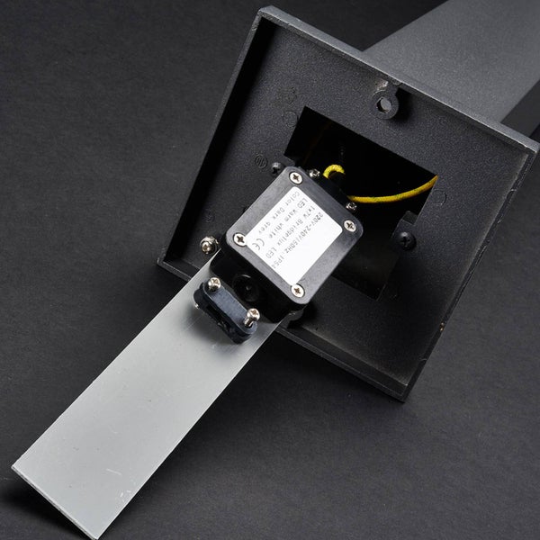 Unterseite einer Außenleuchte mit Anschlusskasten, Montageschiene und Aufkleber mit technischen Daten zur Schutzart IP 54.