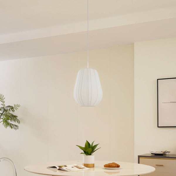 Weiße Pendelleuchte mit geripptem Schirm über einem runden Esstisch in einem hellen, modernen Raum.