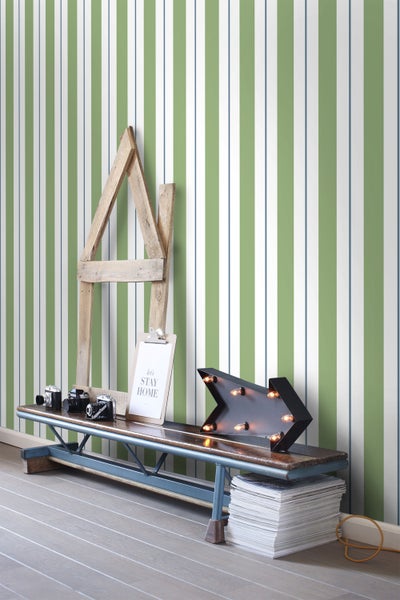 Raum mit gestreifter Tapete, Bank, Dekorationen wie Kameras, beleuchteter Pfeil und Holzrahmen