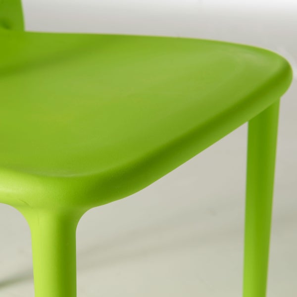 Nahaufnahme der Sitzfläche und eines Stuhlbeins eines grünen Stapelstuhls aus Kunststoff.
