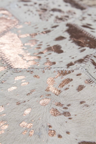 Strukturansicht eines Patchwork Teppichs aus Fellstücken in sechseckiger Form mit metallischen Akzenten.