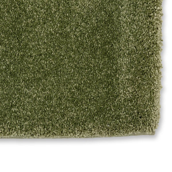 Nahaufnahme eines grünen Hochflor-Teppichs mit weicher Shaggy-Struktur.
