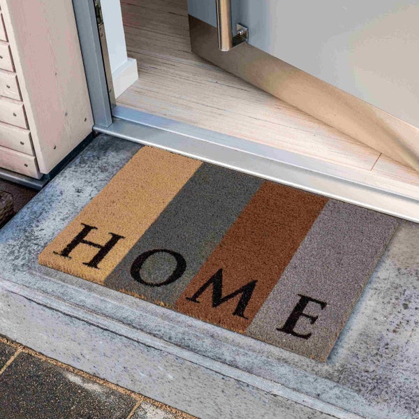 Fußmatte mit der Aufschrift HOME vor einer offenen Tür
