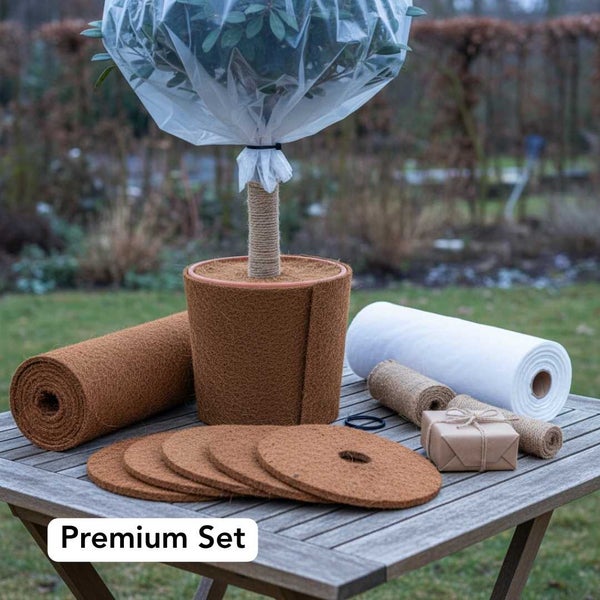 Winterschutz Set für Pflanzen bestehend aus Kokosmatte, Kokosvlies, Winterschutzhaube, Juteschnur und Schutzvlies auf einem Holztisch.