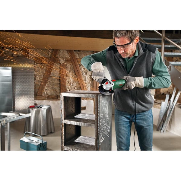 Handwerker schleift Metallregal mit Bosch Winkelschleifer in einer Werkstatt mit Funkenflug