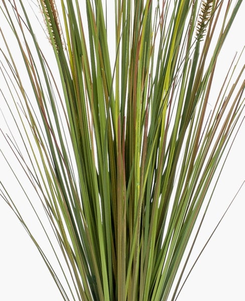 Künstliches grünes Gras in einem schwarzen Kunststofftopf.