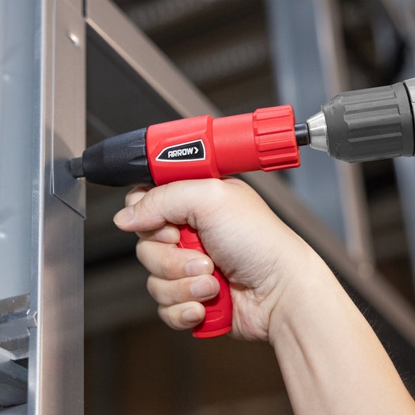 Arrow Blindnietaufsatz mit Arrow Logo für Bohrmaschinen bei der Anwendung an einem Metallgestell.