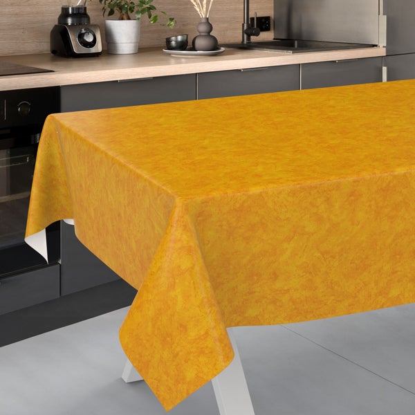 Strukturierte gelbe Tischdecke auf einem Tisch in einer modernen, hellen Küche mit dunklen Schränken und Holzoberflächen.