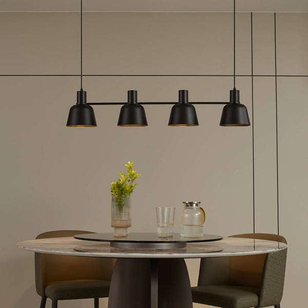 Esstisch mit Blumenvase, Gläsern, Wasserkrug und schwarzer Pendelleuchte mit vier Lampen.