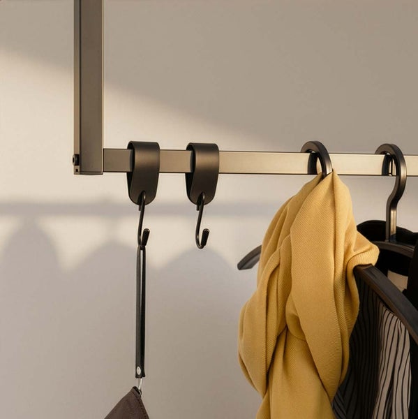 Detailaufnahme einer Garderobenstange mit Haken und Kleidung