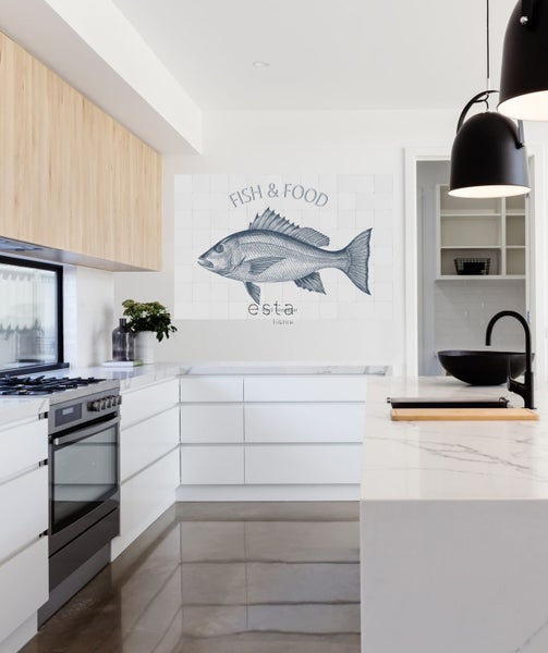 Helle Küche mit Küchenschränken, Herd und Wandbild mit Fischmotiv