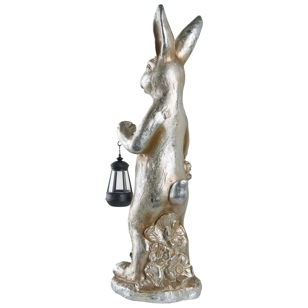 Dekofigur Hase in Silberoptik mit einer schwarzen Laterne auf einem Sockel mit Blumen.