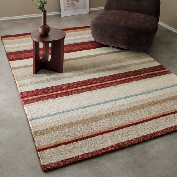 Rechteckiger, gestreifter Wohnzimmerteppich in einem modern eingerichteten Raum mit Beistelltisch und Sessel.