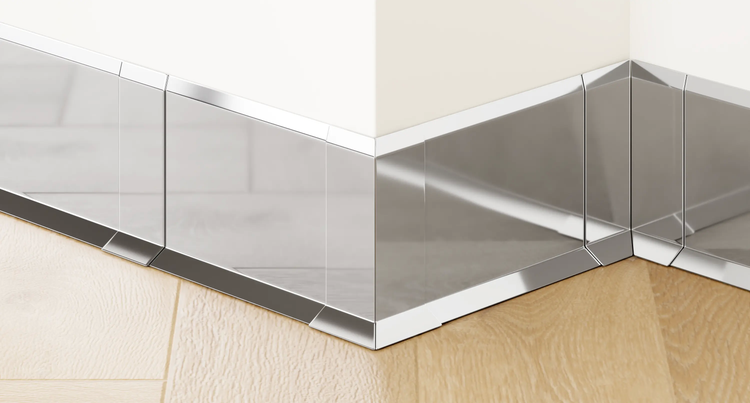 Verlegung von Sockelleisten aus Edelstahl im Eckbereich zwischen Holzboden und Wand