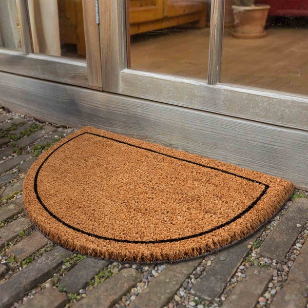 Halbmondförmige Fußmatte aus Kokosfaser mit schwarzem Rand vor einer Tür