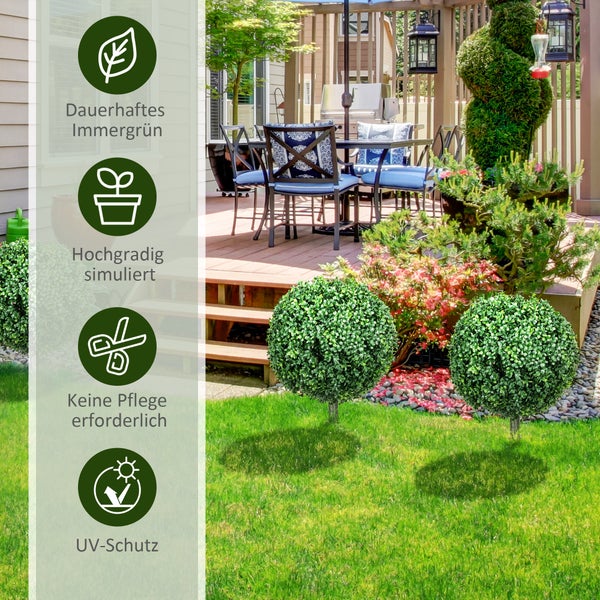 Zwei künstliche Buchsbaumkugeln in schwarzen Töpfen neben einer hölzernen Haustür in einem hellen Eingangsbereich mit Natursteinwand.