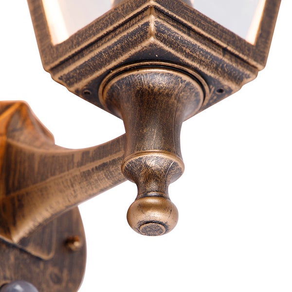 Detailansicht einer Außenwandleuchte im antiken Stil aus Metall mit Glaseinsätzen.