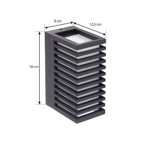 Rechteckige Außenwandleuchte in Schwarz mit Lamellen. Maße: Höhe 18 Zentimeter, Breite 8 Zentimeter, Tiefe 12,5 Zentimeter.