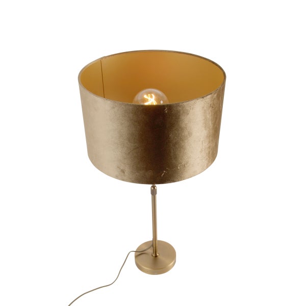 Tischleuchte goldfarben mit zylindrischem Samtschirm und Metallfuß, inklusive sichtbarem Leuchtmittel.