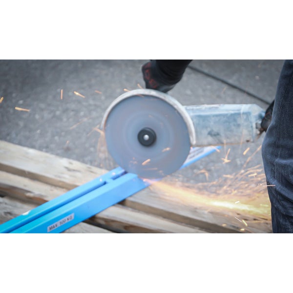 Eine Person schneidet mit einem Winkelschleifer ein blaues Metallstück, Funken fliegen.