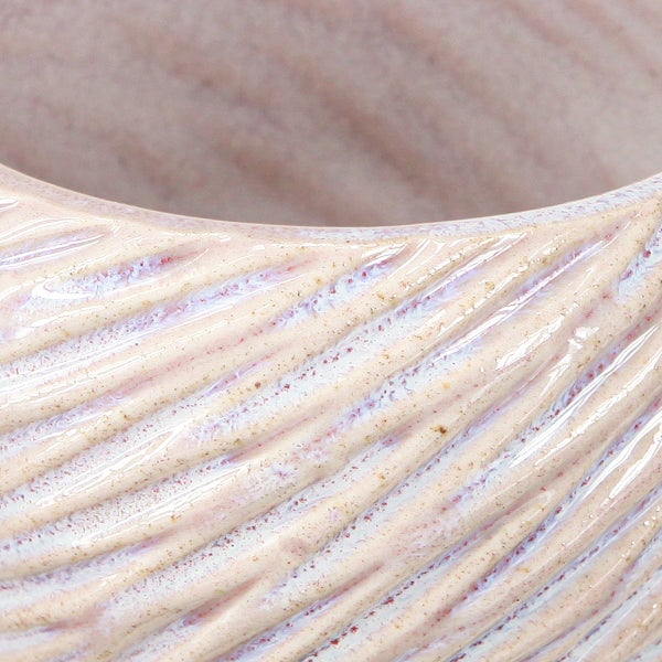 Nahaufnahme eines Keramik-Blumentopfs mit spiralförmiger Reliefstruktur und glasierter Oberfläche.