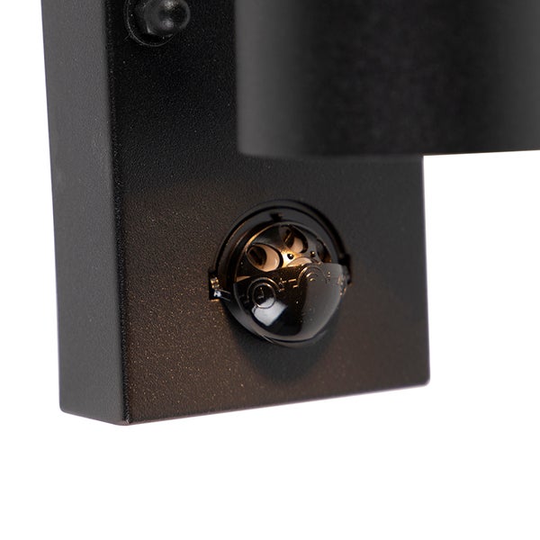 Detailansicht eines einstellbaren Bewegungssensors an einer schwarzen Außenwandleuchte.