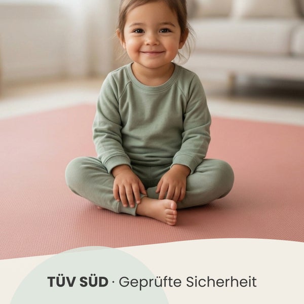 Kind auf einer Spielmatte mit TÜV SÜD geprüfter Sicherheit.