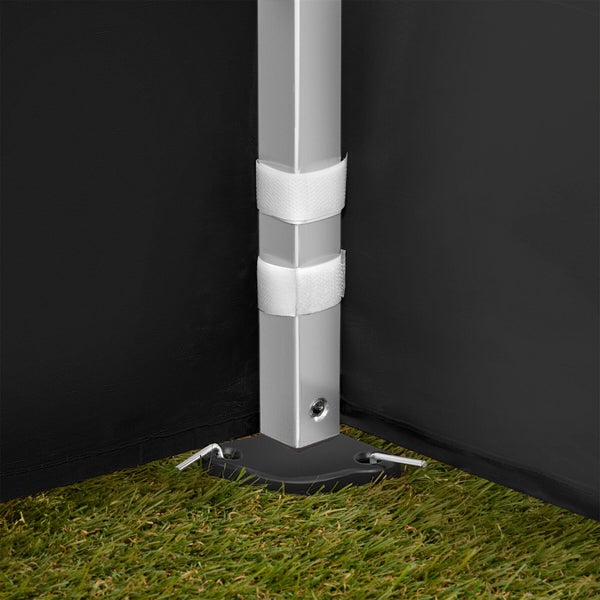 Detailaufnahme eines Pavillonpfostens mit Klettverschluss zur Befestigung der Seitenwände und Bodenheringen zur Verankerung im Gras.