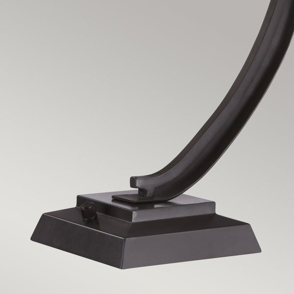 Detailansicht des Sockels und des gebogenen Arms einer Leuchte.