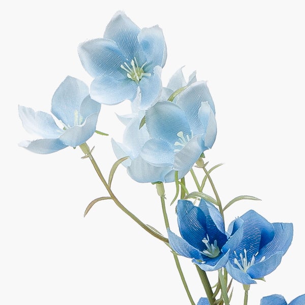 Nahaufnahme eines schwarzen Kunststofftopfes mit dem Stamm einer Kunstpflanze.